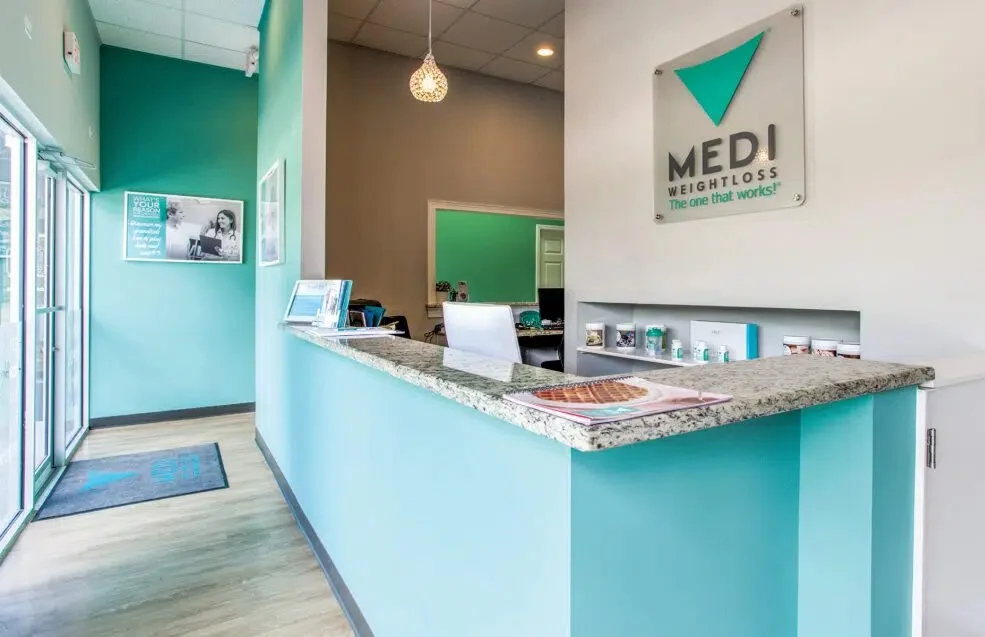 Reception area of Medi-Weightloss Framingham, with a granite front desk and the Medi-Weightloss sign on the wall